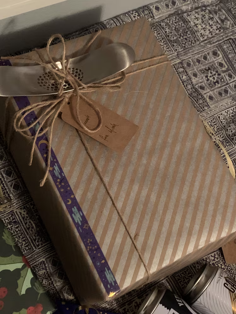 A wrapped gift with a garlic press in the bow